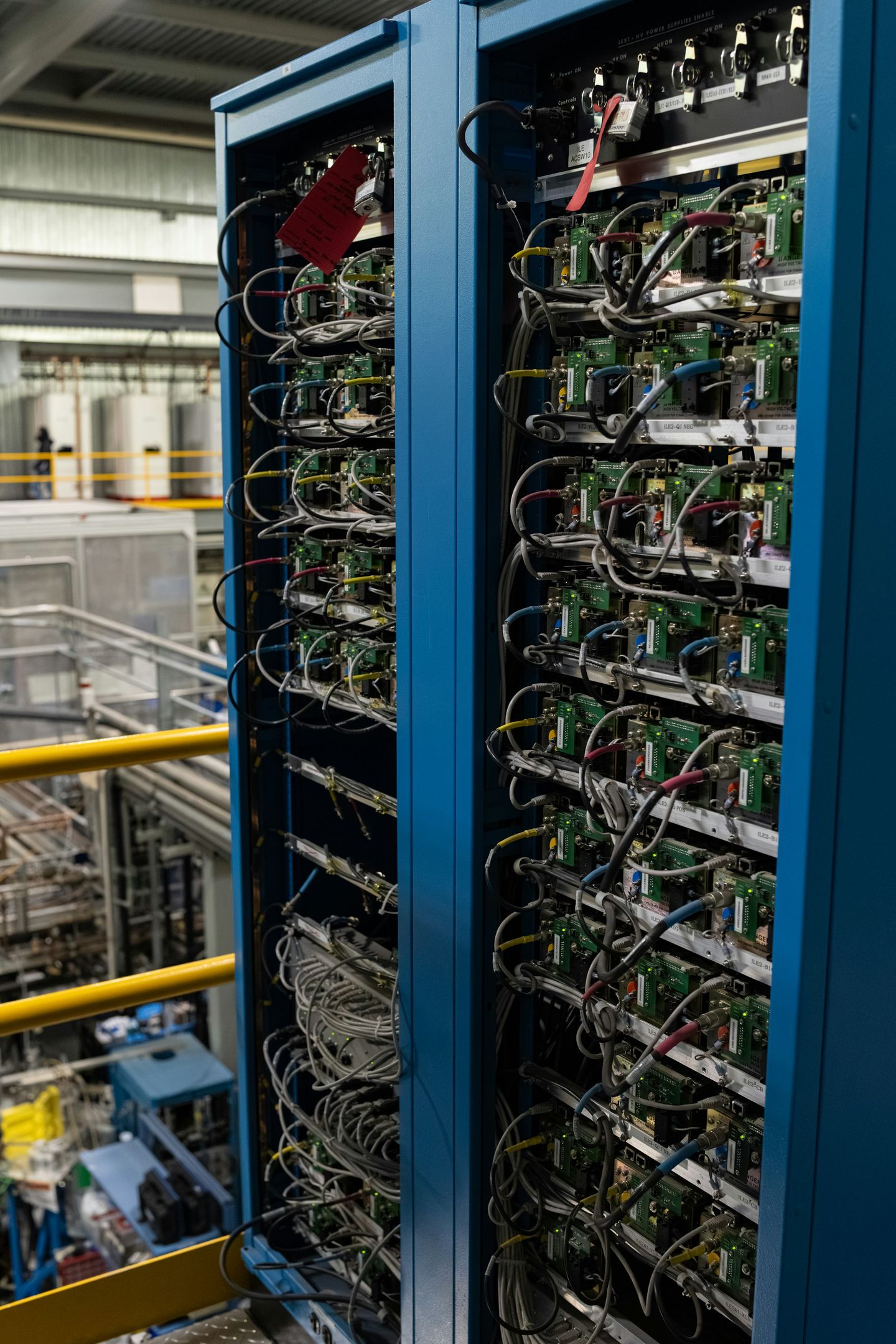 Open blue equipment racks filled with wired electronic modules.