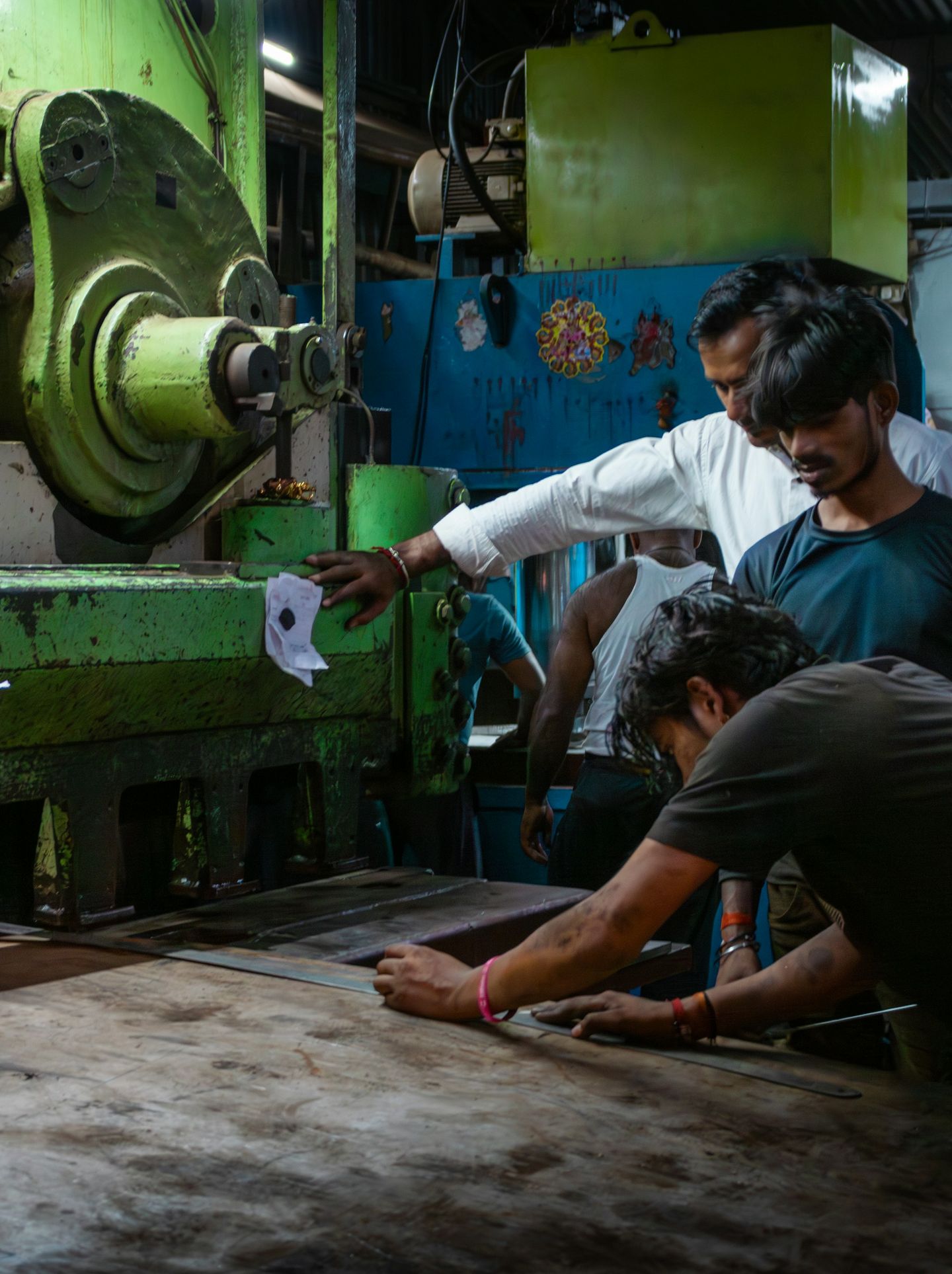 Factory workers operating heavy metalworking machinery.