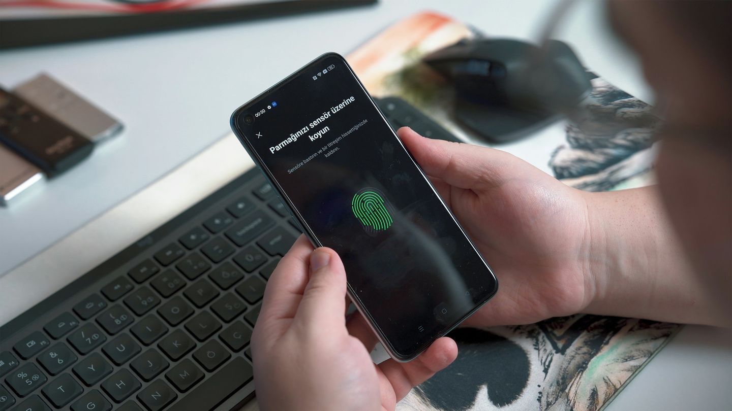 A person enrolling a fingerprint sensor on a smartphone.